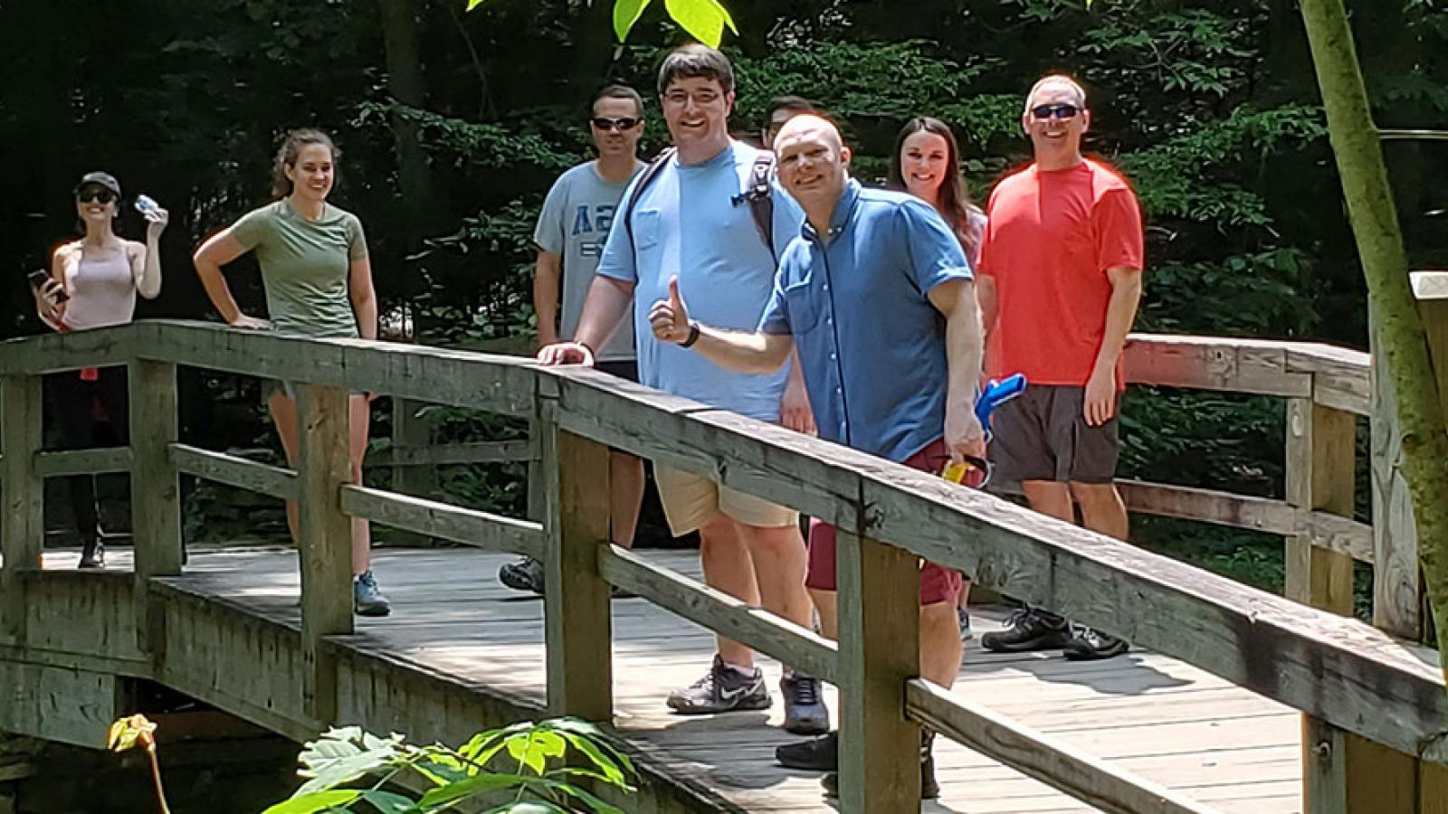 People standing on a bridge in the woods